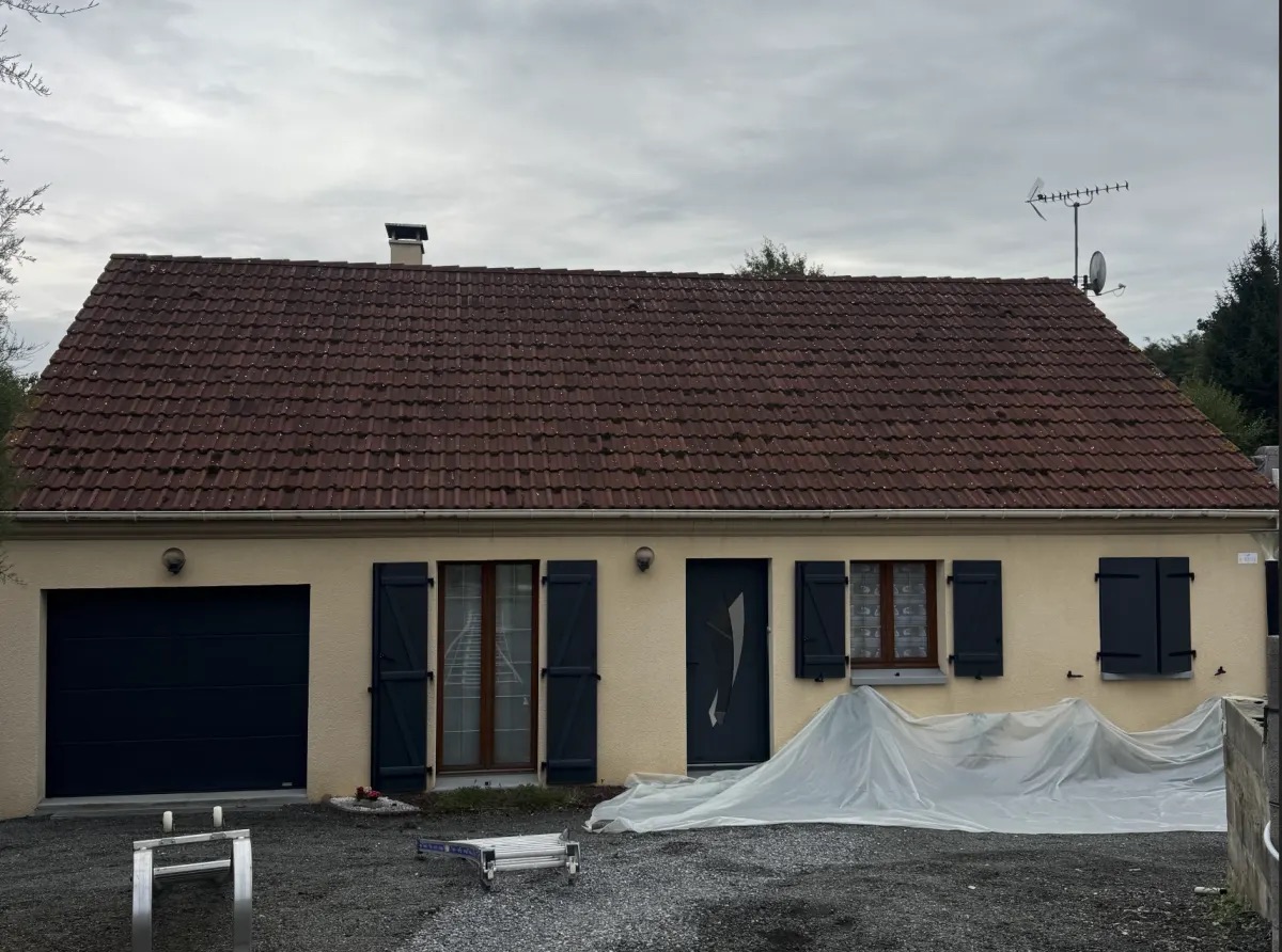 Toiture dont les tuiles ont noirci par plaques sous l'effet des lichens