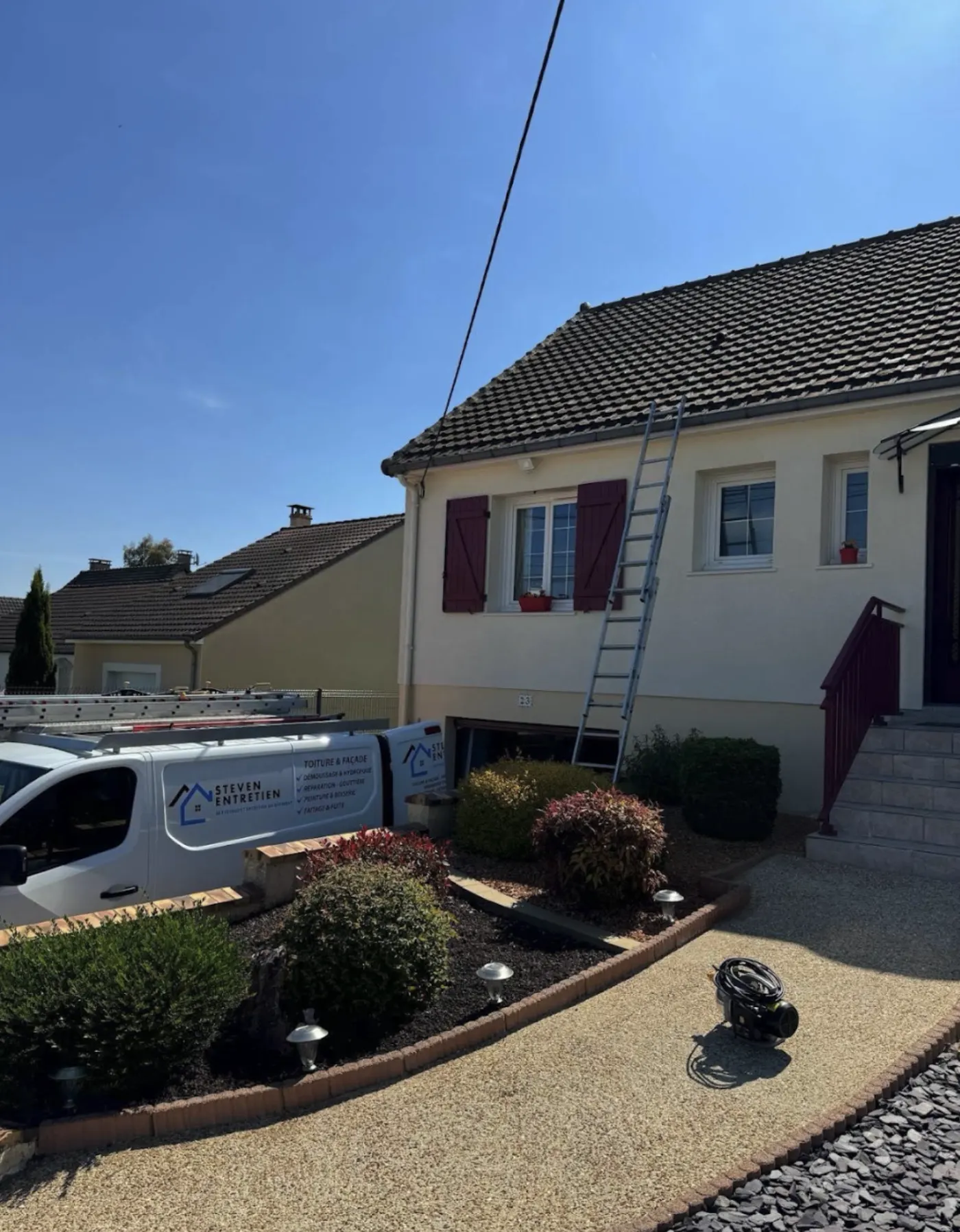 Maison avec toiture en tuile et véhicule Steven Entretien garé devant
